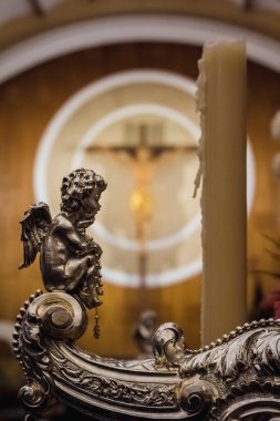 Arka planda bir haç bir melek heykelinin arkasında..