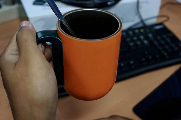 A worker Drinks hot coffee in the morning while working in the office