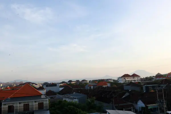 Açık mavi gökyüzü ve beyaz bulutları olan bir şehir manzarası