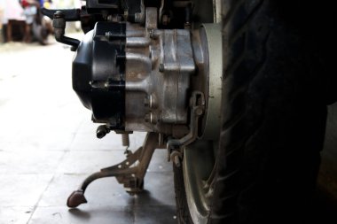 Otomatik motosiklet scooterının altı, motorun ve lastiklerin fotoğrafı.