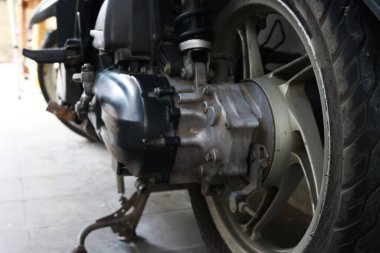 Otomatik motosiklet scooterının altı, motorun ve lastiklerin fotoğrafı.