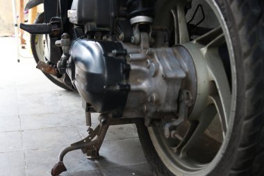 Otomatik motosiklet scooterının altı, motorun ve lastiklerin fotoğrafı.