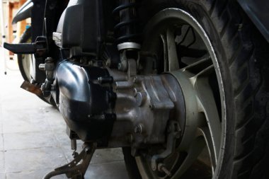Otomatik motosiklet scooterının altı, motorun ve lastiklerin fotoğrafı.