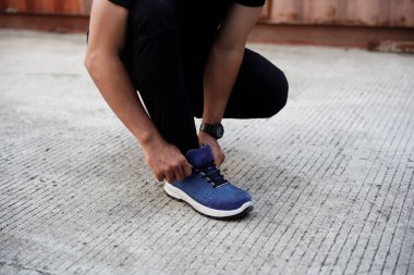    Sabah koşusunda spor ayakkabısı ve eşofman altı giyen bir adamın fotoğrafı.       