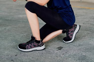 Koşmaya hazırlanan bir genç spor ayakkabı ya da spor ayakkabı giyer.