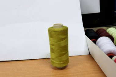 Renkli dikiş ipliklerinin fotoğrafı terzi masasında, genellikle elbise dikmek ya da yırtık pantolon dikmek için kullanılır.