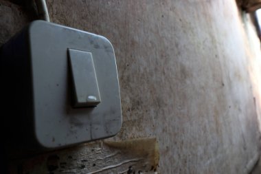 Elektrik düğmesinin fotoğrafı. Güç kaynağını bağlamak ya da kesmek için anahtar fonksiyonları. Evlerde en çok ışıkları açıp kapamak için kullanılır.