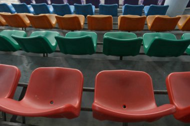 Bir spor stadyumundaki kürsüde renkli bank ya da sandalyelerin fotoğrafı