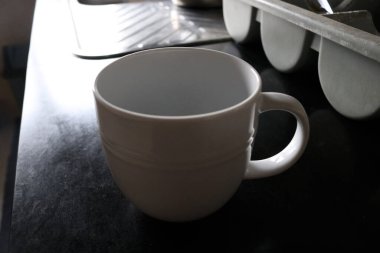 Mutfak masasındaki fincanın beyaz fotoğrafı.