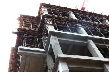 İnşaat halindeki binaların fotoğrafları beton, ahşap, çimento, kum, iskele ve taş gösteriyor.