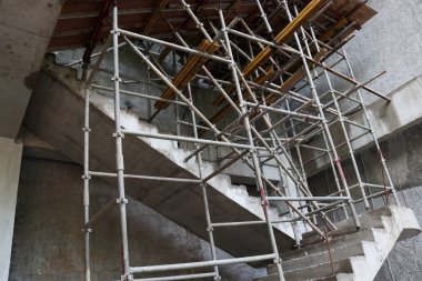 İnşaat halindeki binaların fotoğrafları beton, ahşap, çimento, kum, iskele ve taş gösteriyor.
