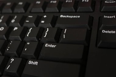 Photo of the black keyboard of a personal computer in an office