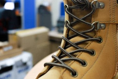 Duvara yaslanmış kahverengi deri ayakkabıların fotoğrafı.