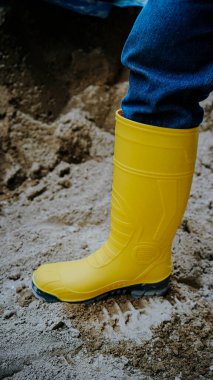 İnşaat halindeki bir binada sarı lastik botların fotoğrafı. Bu lastik botlar su geçirmez ve inşaat işçileri tarafından sıklıkla kullanılır.