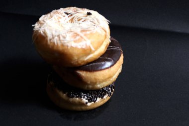 Çikolata, peynir ve çilek aromalı donut fotoğrafları. Çörek ortasında delik olan bir ekmektir.