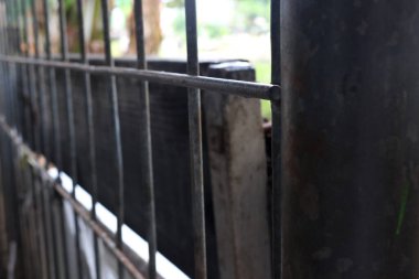 Demirden yapılmış bir ev çitinin fotoğrafı. Genellikle çitler evin önündedir ve evin etrafını sarar.