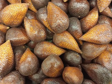 Photo of a pile of brown salak fruit at a fruit market