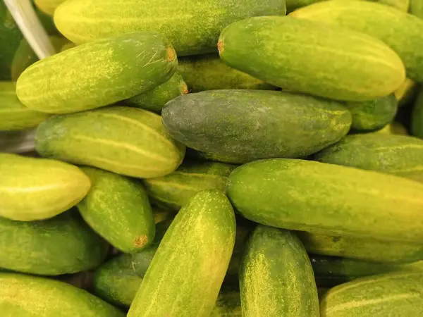 Sebze pazarındaki bir yığın salatalığın fotoğrafı.