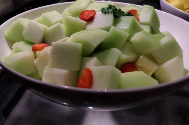 Restoran tabağındaki çeşitli taze ve tatlı meyvelerin fotoğrafı..