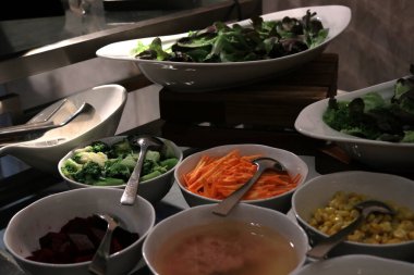 Restoranda yenmeye hazır bir dizi salatanın fotoğrafı..