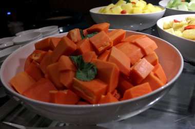 Bir meyve dükkanında kesilmiş taze papaya meyvesinin fotoğrafı..