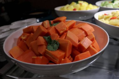 Bir meyve dükkanında kesilmiş taze papaya meyvesinin fotoğrafı..