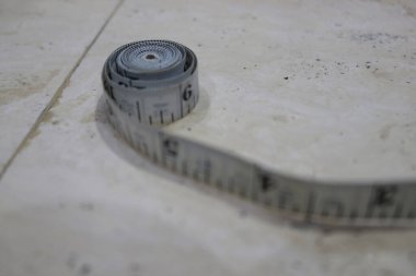 Elbise dikerken ölçmek için bir terzi tarafından kullanılan bir metre resmi