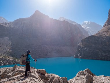 Göl büyük Alo yakınındaki sırt çantası kayalık dağ zemin üzerine olan kız. Fann dağlar, Tacikistan, Orta Asya