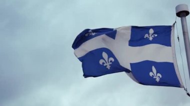 Rüzgarda dalgalanan Quebec bayrağı Kanada Fransız kültürü gri bulutlu şehir politikası