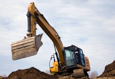 Kazıcı toprak kepçesi döküyor hidrolik kürek inşaat sahasına kazıyor ağır ekipman toprak taşıyıcı 