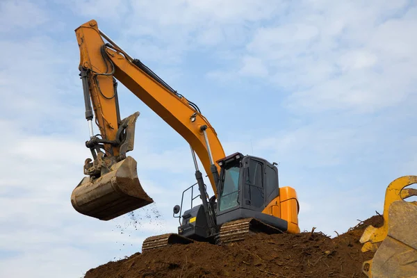 掘削機建設現場で掘削土バックホウ油圧ショベルをダンプ重機土ムーバー — ストック写真