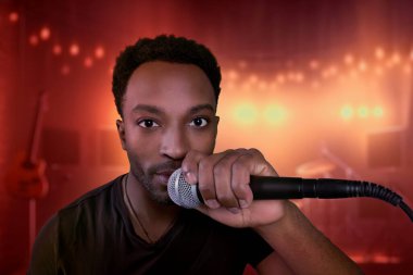 Adam mikrofon barında şarkı söylüyor. Konser, karaoke, eğlence, sahne performansı, gece kulübü.
