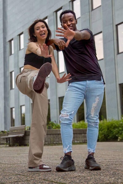 man and woman street style one foot in the air girl jumping couple blocking the camera cool relationship friends