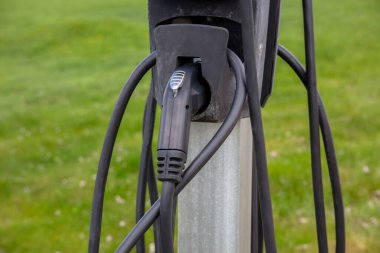 Çevre dostu ulaşım için modern şarj ekipmanı ve kabloları kullanarak elektrikli arabanızı yenilenebilir enerji ile şarj edin..