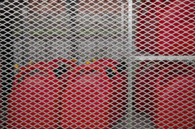 Endüstriyel kırmızı gaz tankları için güvenlikli metal kapı. Yanıcı ekipmanlara kısıtlı erişimi olan güvenlik kavramı.