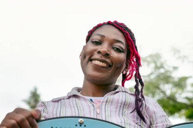 Dost canlısı Afrikalı Amerikan anaokulu öğretmeni, açık havada kızıl örgülü saç stili. Beyaz arka planda sıcak eğitici profesyonel portre. Çocuk bakımı ve anaokulu içeriği.