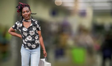 Afro-Amerikalı bir kadın alışveriş merkezinde alışveriş yapmayı seviyor. Tüketici yaşam tarzı, moda perakendecisi, alışveriş davranışı ve ticari pazarlama kavramları için mükemmel.