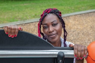 Anaokulundaki mutlu Afrikalı anaokulu öğretmeni eğitimsel profesyonelliği gösteriyor. Gülümseyen çocuk bakımı eğitmeni erken çocukluk gelişimine eğilim gösteriyor.