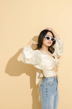 Güzel yüzlü ve mükemmel temiz tenli Asyalı bir kadın. Bej izole arka planda, seksi elbiseli, lüks modaya uygun bir kadın model. Kozmetoloji, E-ticaret, Çevrimiçi alışveriş kavramı.