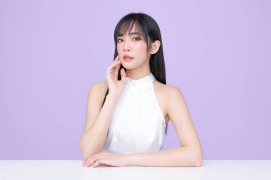 Genç Asyalı güzel kadın, uzun saçlı, doğal makyajlı, izole edilmiş menekşe arkaplanlı, kusursuz ciltli. Yüz bakımı, kozmetoloji, kaplıca, estetik, estetik ameliyat.