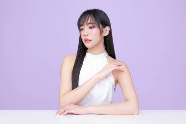 Genç Asyalı güzel kadın, uzun saçlı, doğal makyajlı, izole edilmiş menekşe arkaplanlı, kusursuz ciltli. Yüz bakımı, kozmetoloji, kaplıca, estetik, estetik ameliyat.