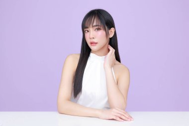 Genç Asyalı güzel kadın, uzun saçlı, doğal makyajlı, izole edilmiş menekşe arkaplanlı, kusursuz ciltli. Yüz bakımı, kozmetoloji, kaplıca, estetik, estetik ameliyat.