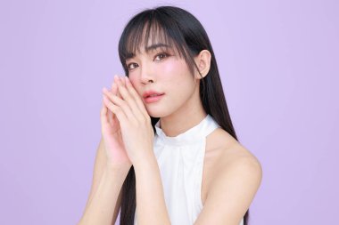 Güzel, genç, Asyalı bir kadın, uzun saçlı, doğal makyajlı, temiz tenli, izole bir menekşe. Tatlı kız portresi, yüz bakımı, vücut bakımı, güzellik ve güzellik merkezi..