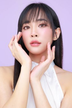 Güzel, genç, Asyalı bir kadın, uzun saçlı, doğal makyajlı, temiz tenli, izole bir menekşe. Tatlı kız portresi, yüz bakımı, vücut bakımı, güzellik ve güzellik merkezi..