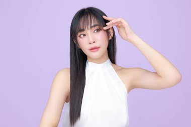 Güzel, genç, Asyalı bir kadın, uzun saçlı, doğal makyajlı, temiz tenli, izole bir menekşe. Tatlı kız portresi, yüz bakımı, vücut bakımı, güzellik ve güzellik merkezi..