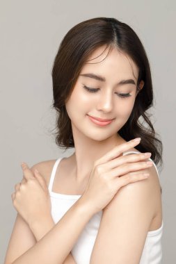 Gri arka planda mükemmel temiz cilde sahip güzel bir Asyalı kadın modeli. Yüz bakımı, yüz bakımı, kozmetik, estetik cerrahi stüdyoda güzel bir kız portresi..