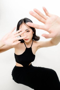 Modaya uygun Asyalı kadın, kısa saçlı, mükemmel vücutlu. Doğal makyajlı, beyaz tenha arka planda ışıl ışıl gözleri olan sevimli bir kadın modeli. Yüz bakımı, kozmetoloji, güzellik konsepti..