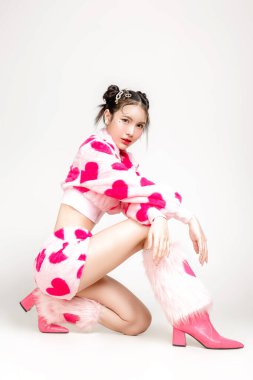 Uzun boylu, güzel, Asyalı bir kadın. Yüzü makyajlı ve beyaz arka planda izole bir şekilde oturan, kalp izi olan mükemmel ince vücutlu bir kadın. Valentine, aşkım, estetik ameliyat konsepti.