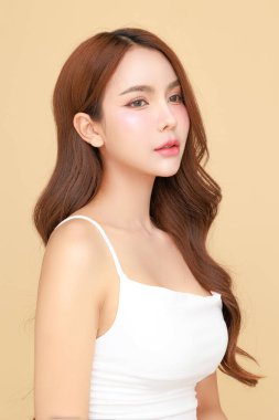 Güzel, genç Asyalı kadın model uzun saçlı, doğal makyajlı izole edilmiş bej arka planda temiz ciltli. Tatlı kız portresi, yüz bakımı, vücut bakımı, güzellik ve güzellik merkezi..