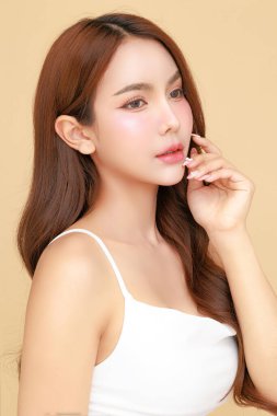 Güzel, genç Asyalı kadın model uzun saçlı, doğal makyajlı izole edilmiş bej arka planda temiz ciltli. Tatlı kız portresi, yüz bakımı, vücut bakımı, güzellik ve güzellik merkezi..